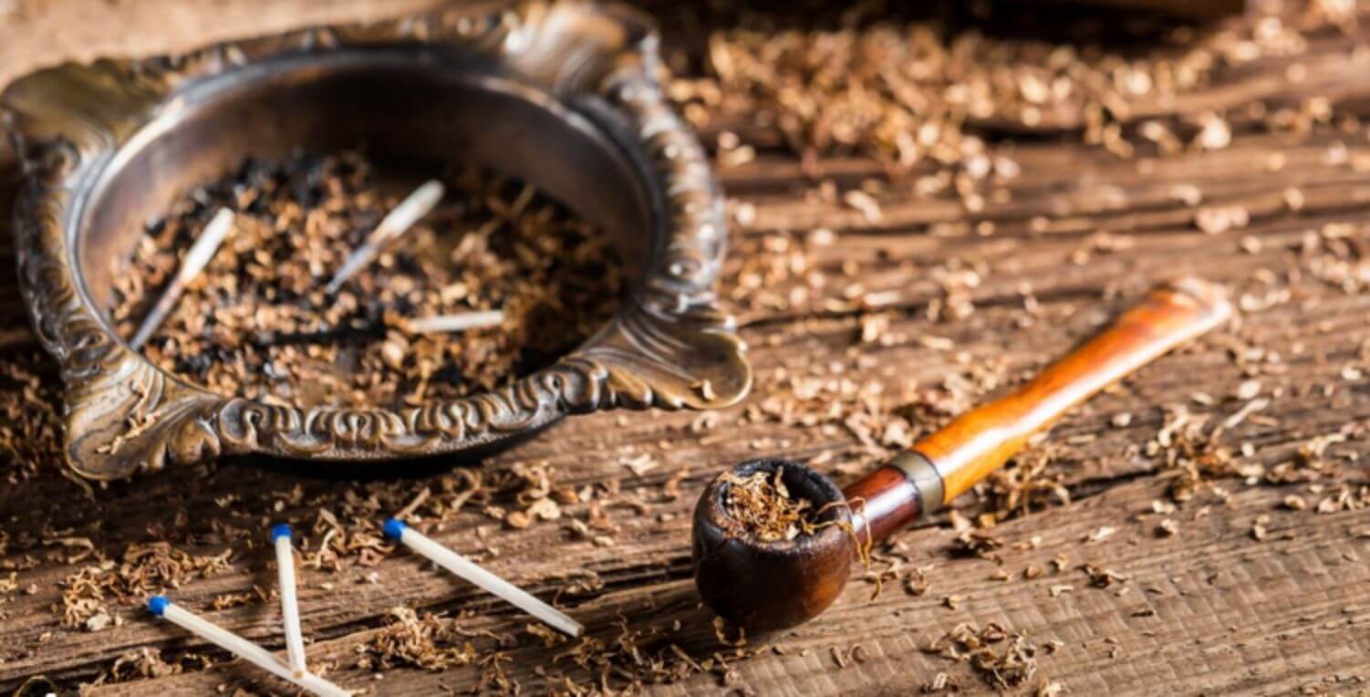 A well-crafted pipe and a tin of Simply Latakia tobacco on a wooden table